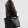 Bolso de piel con hebilla de Prada y cinturón con tachuelas Bolso de piel con hebilla de Prada y cinturón con tachuelas