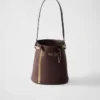 Bolso tipo cubo de piel con hebilla de Prada y cinturón con joyas Bolso tipo cubo de piel con hebilla de Prada y cinturón con joyas