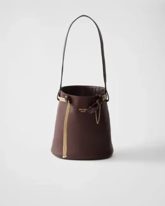 Bolso tipo cubo de piel con hebilla de Prada y cinturón con joyas