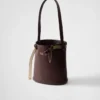 Bolso tipo cubo de piel con hebilla de Prada y cinturón con joyas Bolso tipo cubo de piel con hebilla de Prada y cinturón con joyas