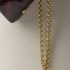 Bolso tipo cubo de piel con hebilla de Prada y cinturón con joyas Bolso tipo cubo de piel con hebilla de Prada y cinturón con joyas