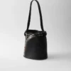 Bolso tipo cubo de piel con hebilla de Prada y cinturón con tachuelas Bolso tipo cubo de piel con hebilla de Prada y cinturón con tachuelas