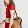 Bolso tipo cubo de piel con hebilla de Prada y cinturón con tachuelas Bolso tipo cubo de piel con hebilla de Prada y cinturón con tachuelas