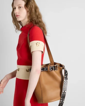 Bolso tipo cubo de piel con hebilla de Prada y cinturón con tachuelas