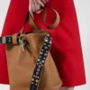 Bolso tipo cubo de piel con hebilla de Prada y cinturón con tachuelas Bolso tipo cubo de piel con hebilla de Prada y cinturón con tachuelas